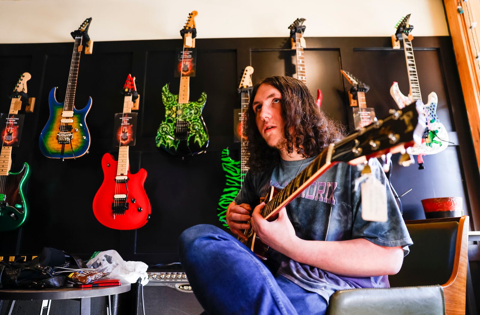 Roman Snyder, 17, plays guitar inside Immortal Vibes Monday, March 17, 2025 in Hamilton. Immortal Vibes is a cocktail and bourbon bar, a coffee shop, a guitar store, and a music venue all in one. NICK GRAHAM/STAFF