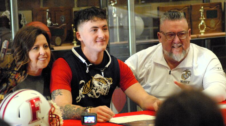 Fairfield's Talon Fisher is pictured with his parents Jonathan and Michelle during a signing day event at Fairfield High School on Wednesday. Fisher will continue his football career at the Naval Academy. Chris Vogt/CONTRIBUTED