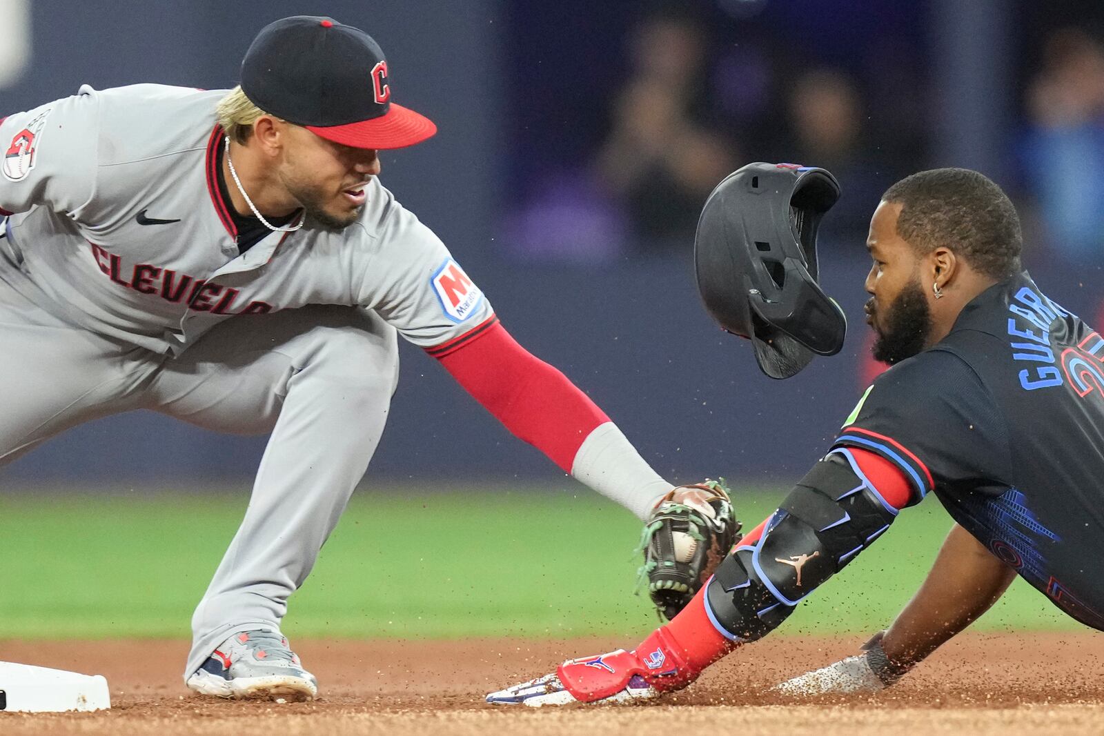 Toronto Blue Jays' Vladimir Guerrero Jr. is tagged out at second base by Cleveland Guardians second baseman Gabriel Arias during the first inning of a baseball game in Toronto on Friday, May 2, 2025. (Chris Young/The Canadian Press via AP)