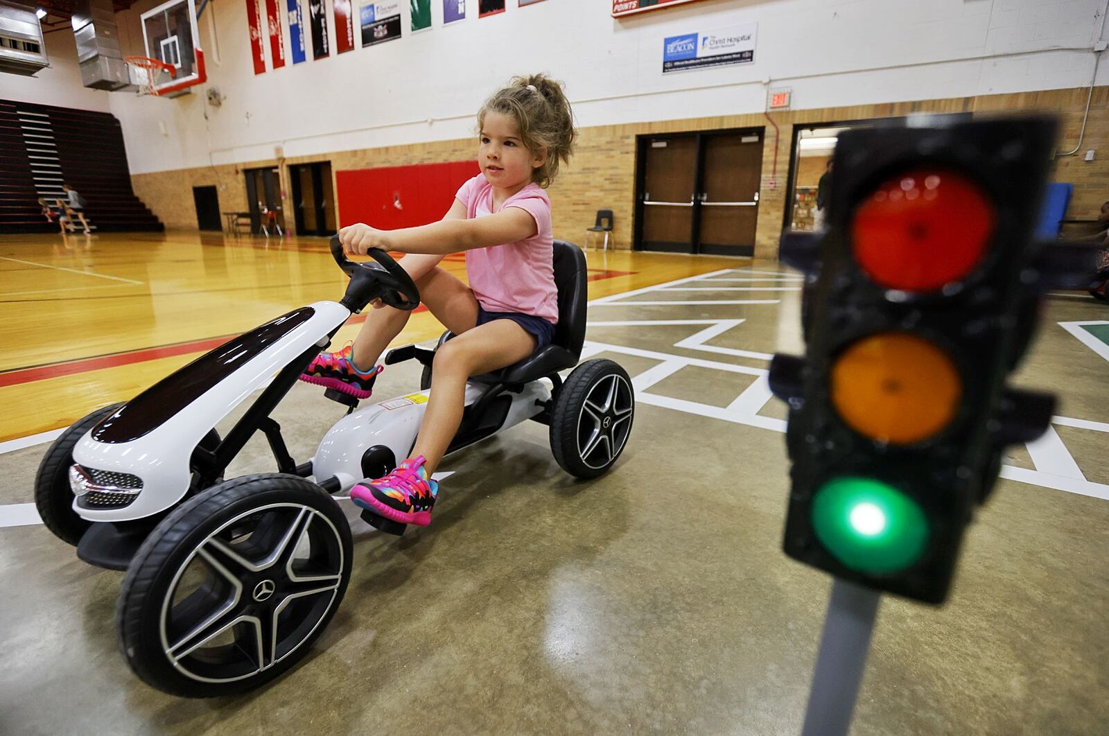 Evelyn Sweemer, 5, drives a pedal car during Lakota Safety Village.  Lakota schools, West Chester Police Department, Butler County Sheriff's Office and other have partnered for Lakota Safety Village to teach young children going into kindergarten school etiquette, bus and car safety, fire safety and more at Lakota Freshman School in West Chester Township. NICK GRAHAM/STAFF