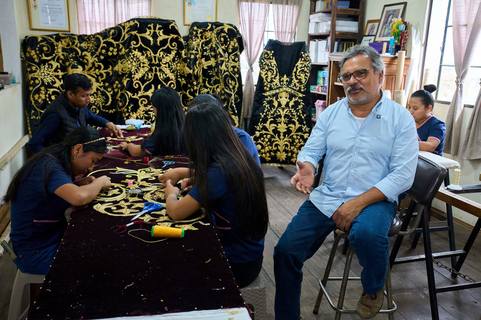 Guatemalan artist Alejandro Juarez gives an interview at the Maria Auxiliadora embroidery workshop in San Miguel Escobar, Guatemala, Wednesday, April 2, 2025. (AP Photo/Moises Castillo)