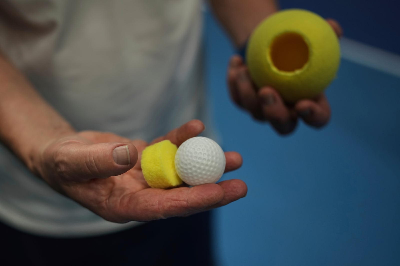 Tennis coach, Lee Neale, shows a ball used for visually impaired tennis during a training session in London, Wednesday, May 14, 2025. (AP Photo/Kin Cheung)