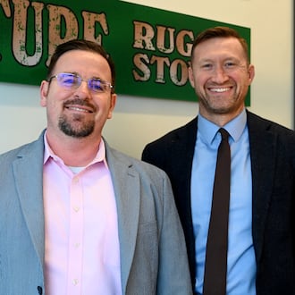 Josh Hodges (left) and Scott Kruger stand inside their new law office, Kruger & Hodges at the corner of South Third and Ludlow streets on Nov. 24, 2025, in Hamilton. During renovation, they uncovered what may be the original glass to the 19th-century building. The glass was painted advertising a former furniture store, but they couldn't remove it without breaking it. Hodges and Kruger had replicated the painted glass and it's on display in the office. MICHAEL D. PITMAN/STAFF