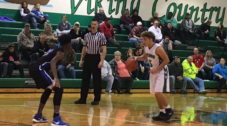 New Miami’s Trey Robinette (5) dribbles toward Cincinnati Christian’s Cameron Rogers during Tuesday night’s game at New Miami. RICK CASSANO/STAFF