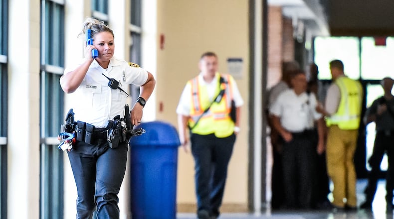 Hamilton police officer Amanda Cox runs down the hallway of Hamilton High School during a training drill with Hamilton City School District in June.