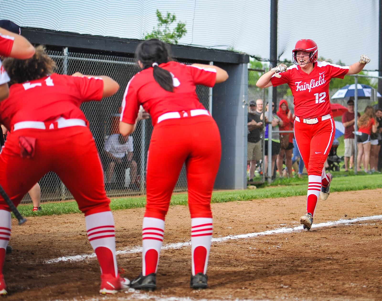 Fairfield’s Lindsey Mitchell is greeted at home plate by her teammates after hitting a two-run homer in Friday’s Division I district softball final against Lakota West at Lakota East. West won 8-2. NICK GRAHAM/STAFF
