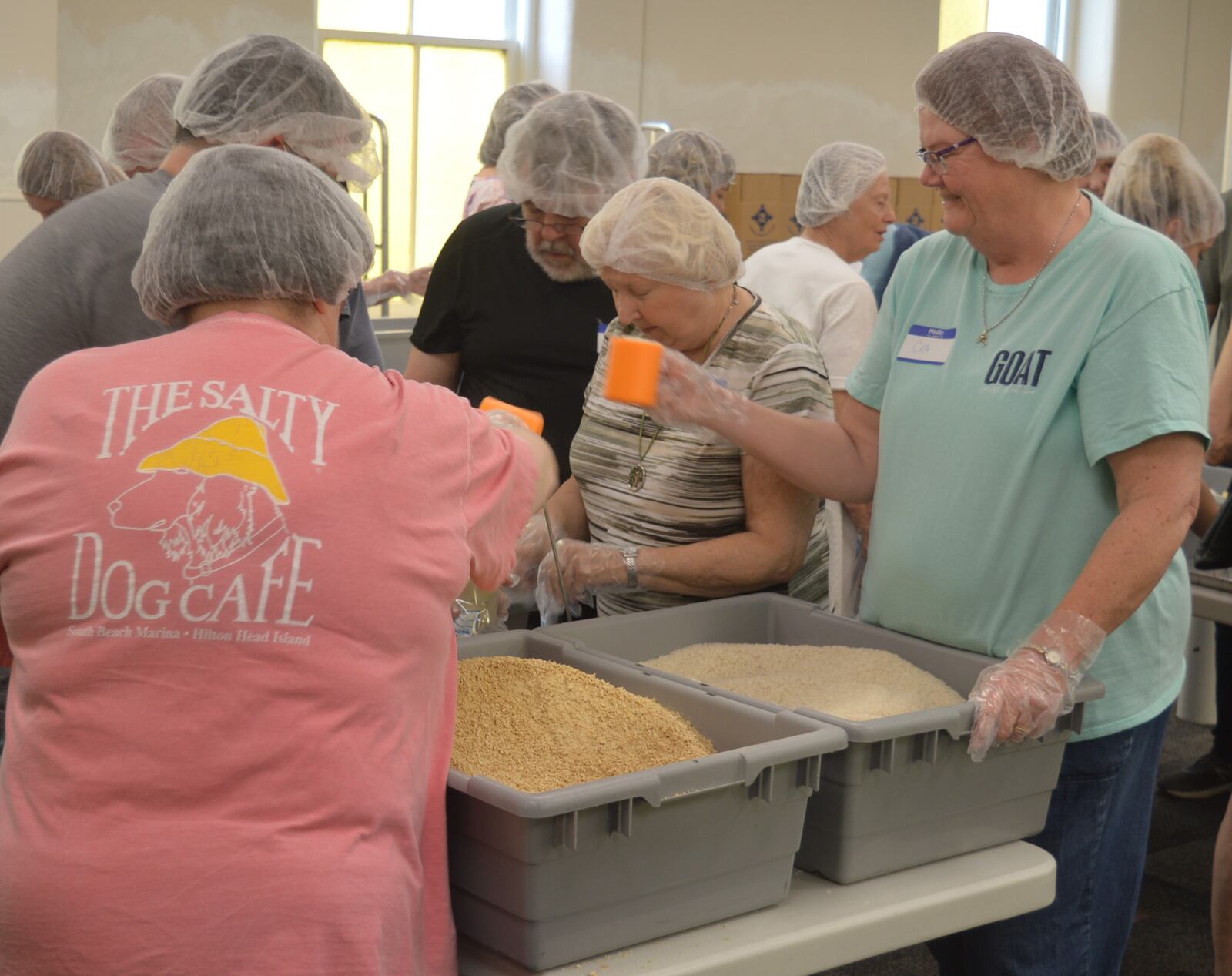 Volunteers measure the grains to fill the bags as part of the food packing event with Kids Coalition Against Hunger last Sunday hosted by the Oxford Presbyterian Church. The grains included in each bag were soy, vegetable, vitamin and rice. CONTRIBUTED/BOB RATTERMAN
