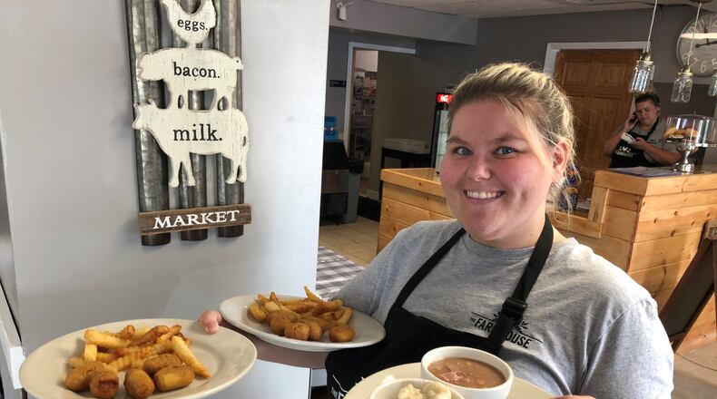 Barb Nease, who co-owns Farmhouse Diner in Trenton with her mother, delivers plates of food to customers soon after the restaurant opened last summer. Nease announced the diner is closing at the end of the month due to a lack of reliable employees and rising food costs. RICK McCRABB/STAFF