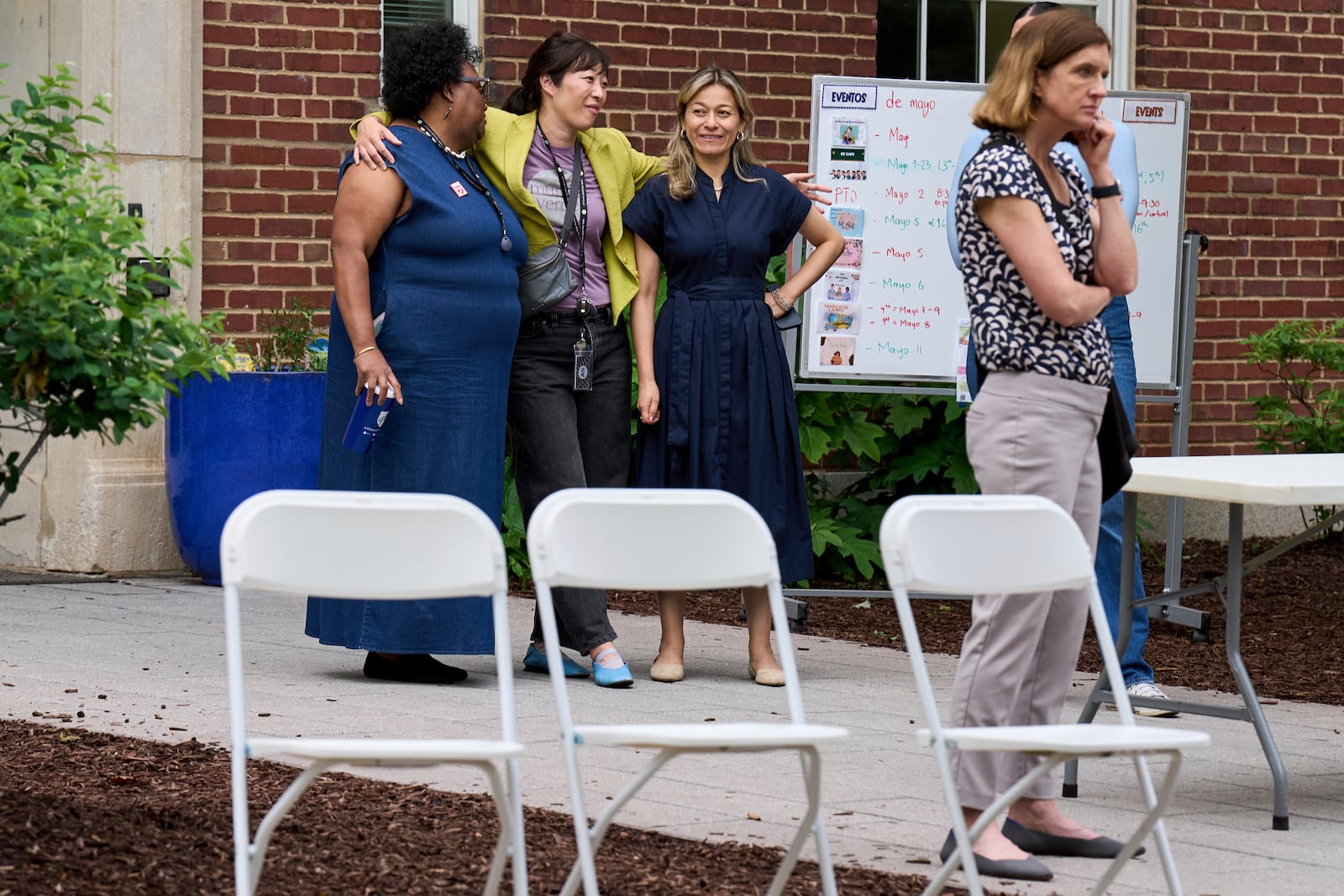 Staff at Mundo Verde Public Charter School hug by chairs set up for parents, as staff and parents keep watch for Immigration and Customs Enforcement (ICE) agents amid fears of impending arrests at schools, Tuesday, May 6, 2025. (AP Photo/Jacquelyn Martin)