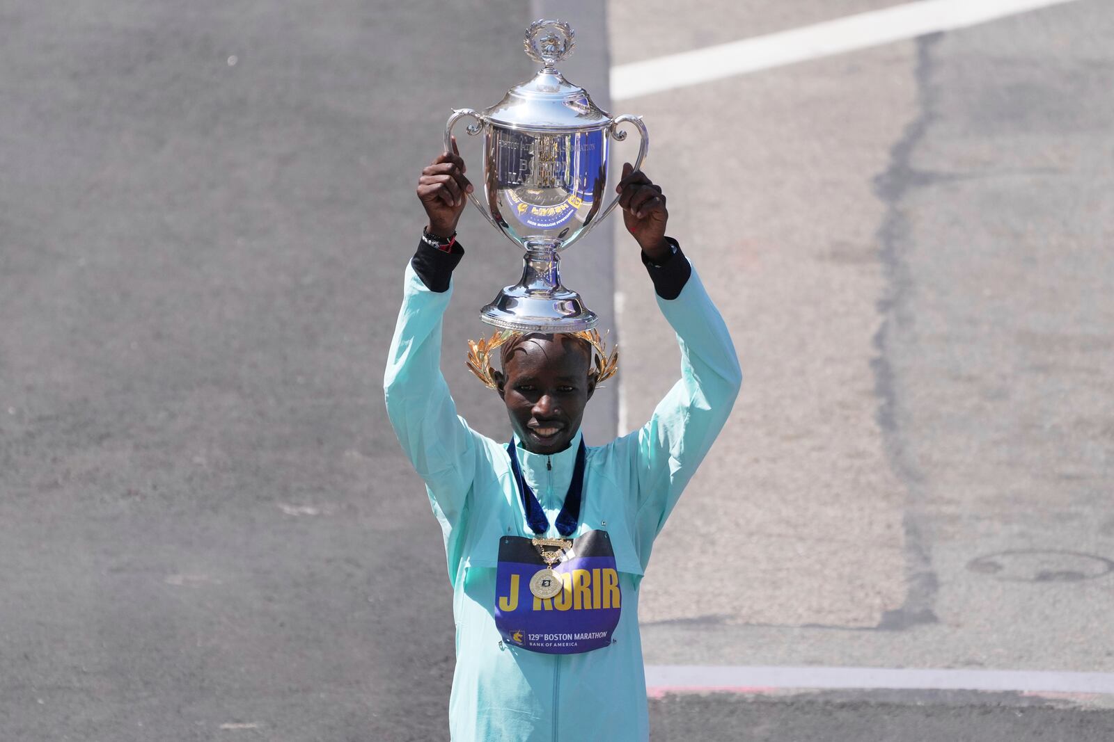Boston Marathon winner John Korir, of Kenya, hoists the trophy while celebrating after the race, Monday, April 21, 2025, in Boston. (AP Photo/Charles Krupa)