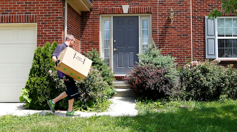 Travis Worrell delivers a package Wednesday, July 16, 2014, to a home in Liberty Twp. NICK DAGGY / STAFF