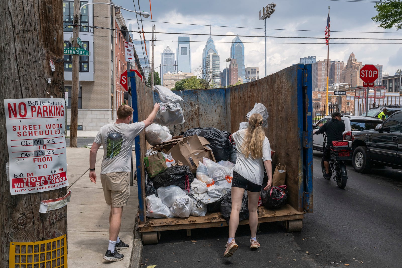 Southwest Center City residents dispose of their garbage at a designated trash collection site on Catharine Street and South 18th Street in Philadelphia, on Tuesday, July 1, 2025. (Kaiden J. Yu/The Philadelphia Inquirer via AP)