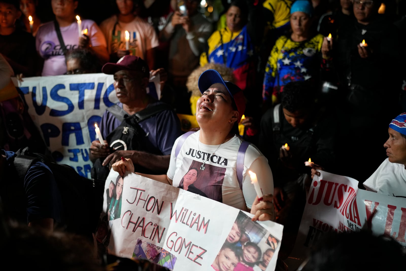 People with photos of their relatives who were deported from the U.S. to a prison in El Salvador, for being alleged members of the Tren de Aragua gang, cry and pray outside El Salvador's embassy in Caracas, Venezuela, April 2, 2025. (AP Photo/Ariana Cubillos)