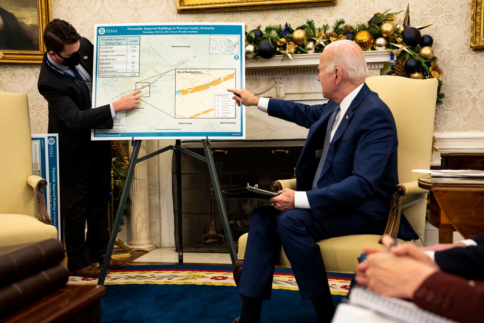 President Joe Biden points to a map showing the Bowling Green, Ky. area, in the Oval Office of the White House in Washington on Monday, Dec. 13, 2021, as he speaks about the Federal response to the tornadoes that impacted multiple states. After grimly fluctuating death tolls since Friday’s devastating swarm of tornadoes, Gov. Andy Beshear of Kentucky said on Monday that there were 64 confirmed deaths in the state, though he expected that number to rise as crews continued to search through the ruins. (Doug Mills/The New York Times)