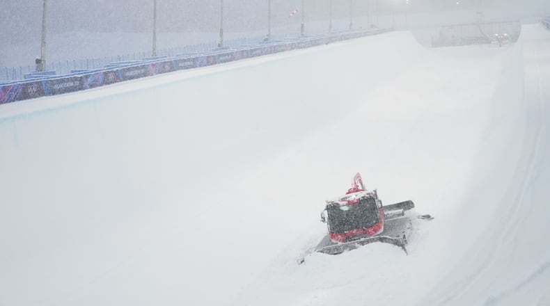 A worker clears snow from the course before the women's freestyle skiing halfpipe final at the 2026 Winter Olympics, in Livigno, Italy, Saturday, Feb. 21, 2026. (AP Photo/Lindsey Wasson)