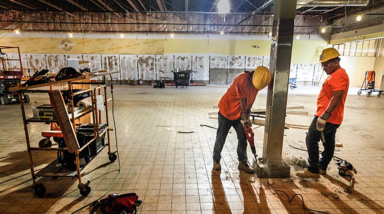 Daryl Gallego, left, and Juan Herrara, employees of Environmental Demolition Group, remove concrete that once protected a post from shopping carts inside the former ALDI store at Westown Shopping Center. Construction is underway on Montgomery County's new Employment Opportunity Center at the site to bring job services and training to an underserved area of the county, according to officials. CHRIS STEWART / STAFF