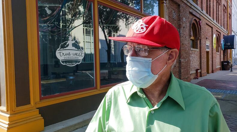 Vernon Burge, 60, from Hamilton, wears a mask as he rides his bike along High Street Wednesday, July 8, 2020 in Hamilton. Burge is for the mask ordinance set forth by Govnernor Dewine in counties with level 3 or level for public health emergency status. NICK GRAHAM / STAFF