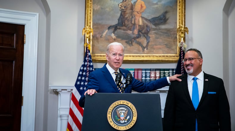 **EMBARGO: No electronic distribution, Web posting or street sales before 3:01 a.m. ET Tuesday, Aug. 30, 2022. No exceptions for any reasons. EMBARGO set by source.** President Joe Biden recognizes Education Secretary Miguel Cardona while speaking about a student loan debt relief plan in the Roosevelt Room of the White House in Washington on Aug. 24, 2022. Liberals and more moderate Democrats are arguing over the impact on inflation, the federal budget deficit and high earners. (Al Drago/The New York Times)