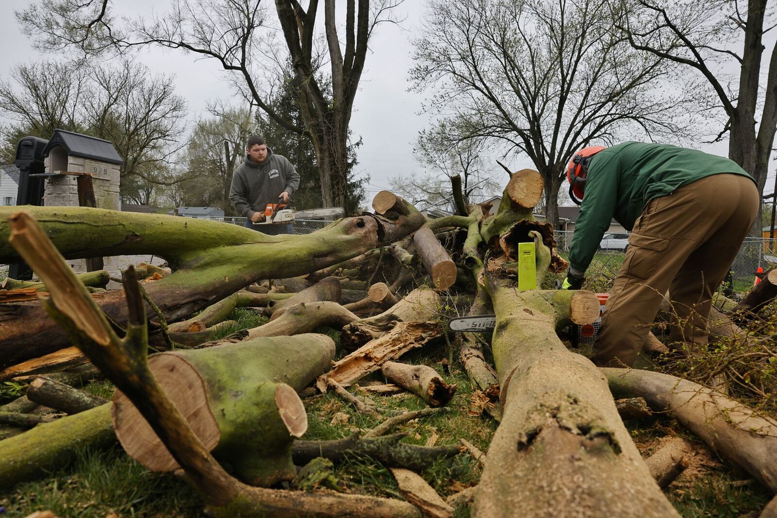 Crews cut up a tree blocking Fenton Street in St. Clair Township after storms overnight caused damage around the area. NICK GRAHAM/STAFF