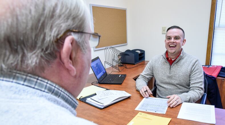 Casey James, right, service officer with the Butler County Veterans Service Commission, meets with a client in the new Middletown branch office on Breiel Boulevard earlier this year. NICK GRAHAM/STAFF