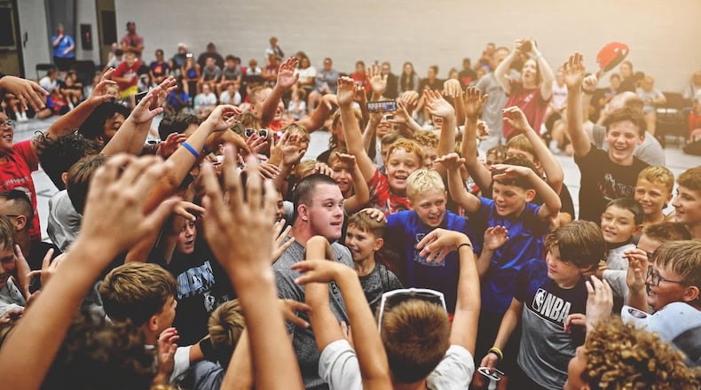 The campers at the Luke Kennard Basketball Camp surround Luke Atkinson, who has Down syndrome, after he sank a 3-pointer right before halftime last weekend. SUBMITTED PHOTO
