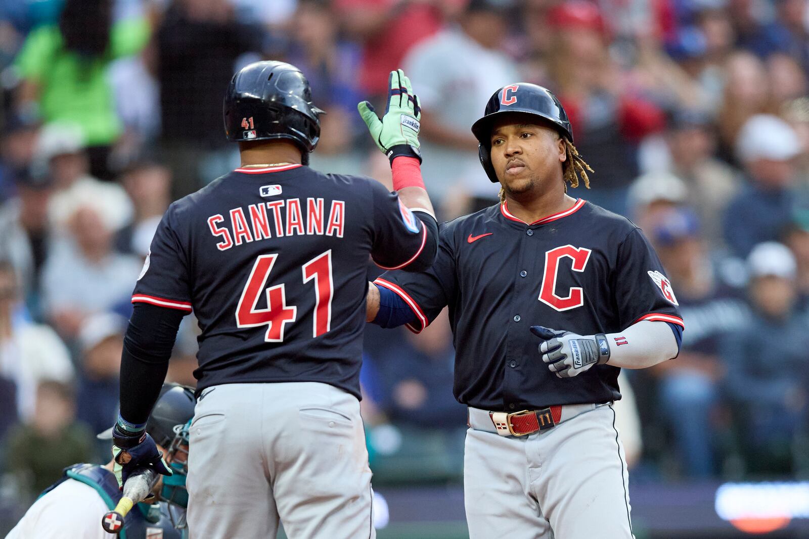 Cleveland Guardians' José Ramírez, right, is greeted at home by Carlos Santana (41) on his solo home run against the Seattle Mariners during the fifth inning of a baseball game, Saturday, June 14, 2025, in Seattle. (AP Photo/John Froschauer)