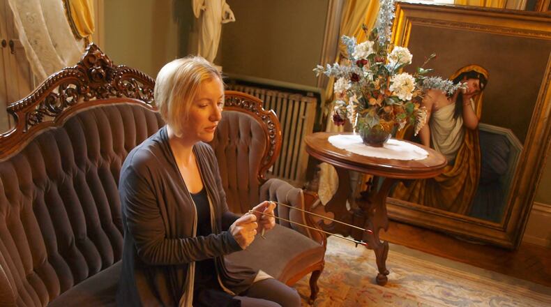 Lynne Bell, an investigator for the Tri-State Ohio Paranormal Society, communicates with Wilhelmina Benninghofen with a pair of divining rods.