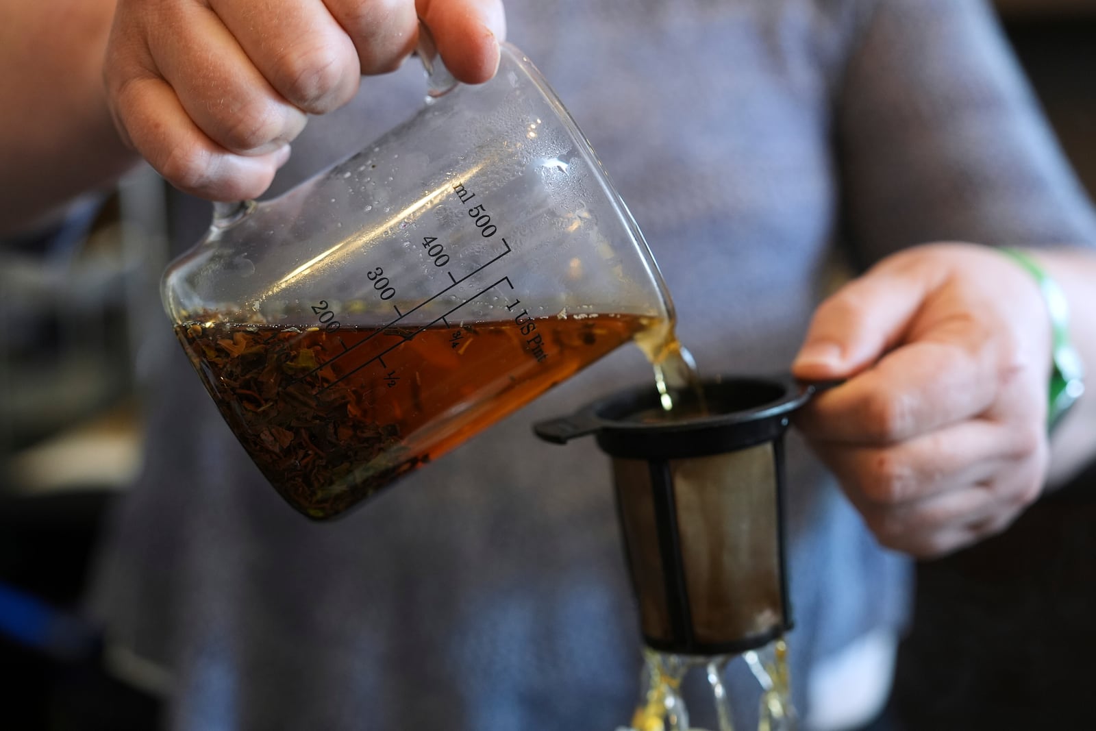 Loose leaf tea is strained for an order at the TeaHaus Thursday, April 24, 2025, in Ann Arbor, Mich. (AP Photo/Paul Sancya)