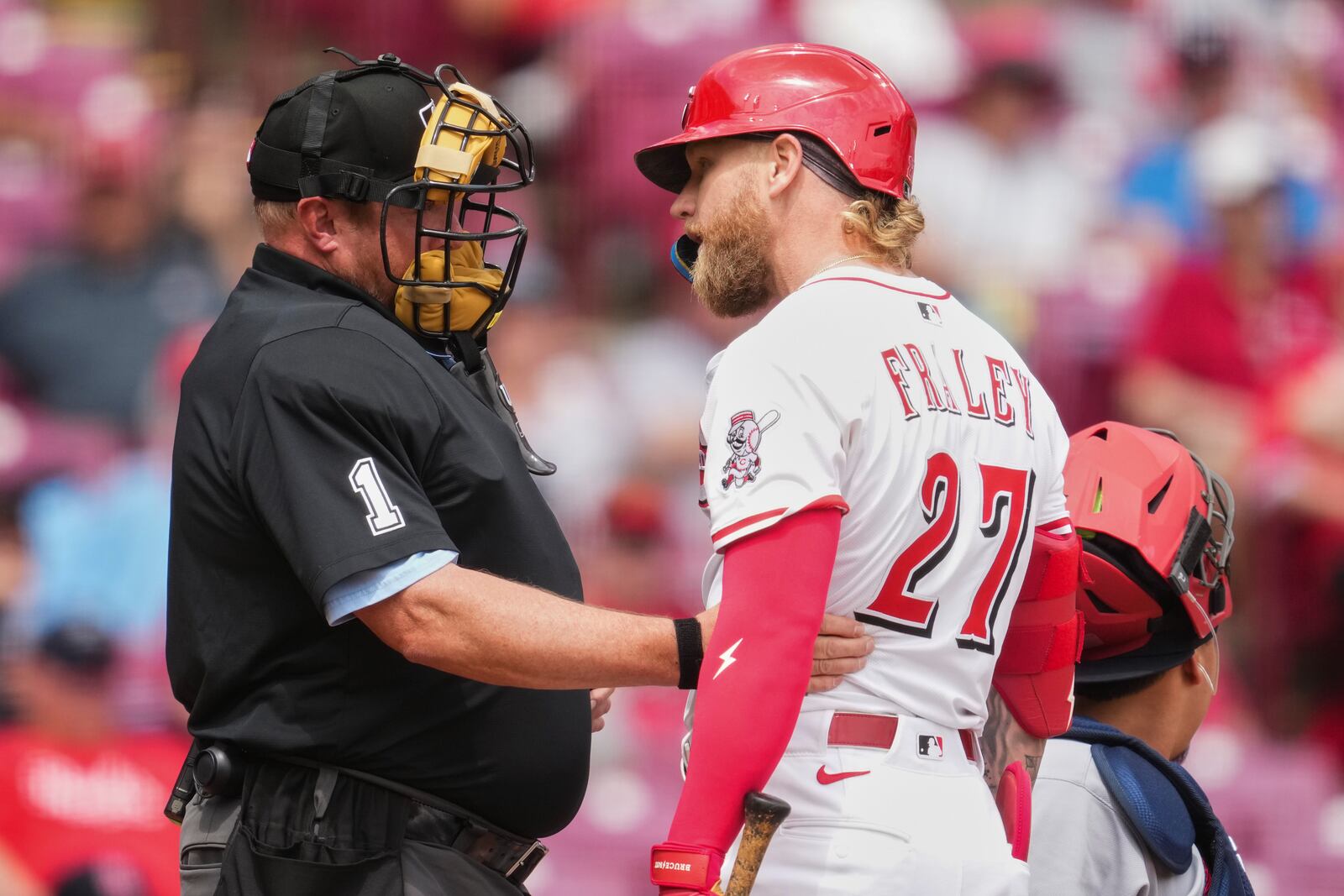 Cincinnati Reds' Jake Fraley (27) reacts to a called strike by umpire Bruce Dreckman (1) during the seventh inning of the first baseball game of a doubleheader against the St. Louis Cardinals Wednesday, April 30, 2025, in Cincinnati. (AP Photo/Jeff Dean)