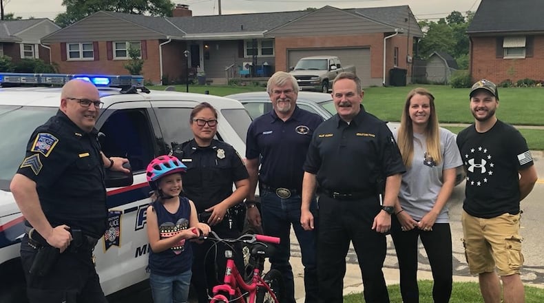 Members of the Middletown Division of Police and FOPA President Perry Davis presented Raelyn Basham with a new bike Wednesday after the bike she received for Easter was stolen Monday. SUBMITTED PHOTO