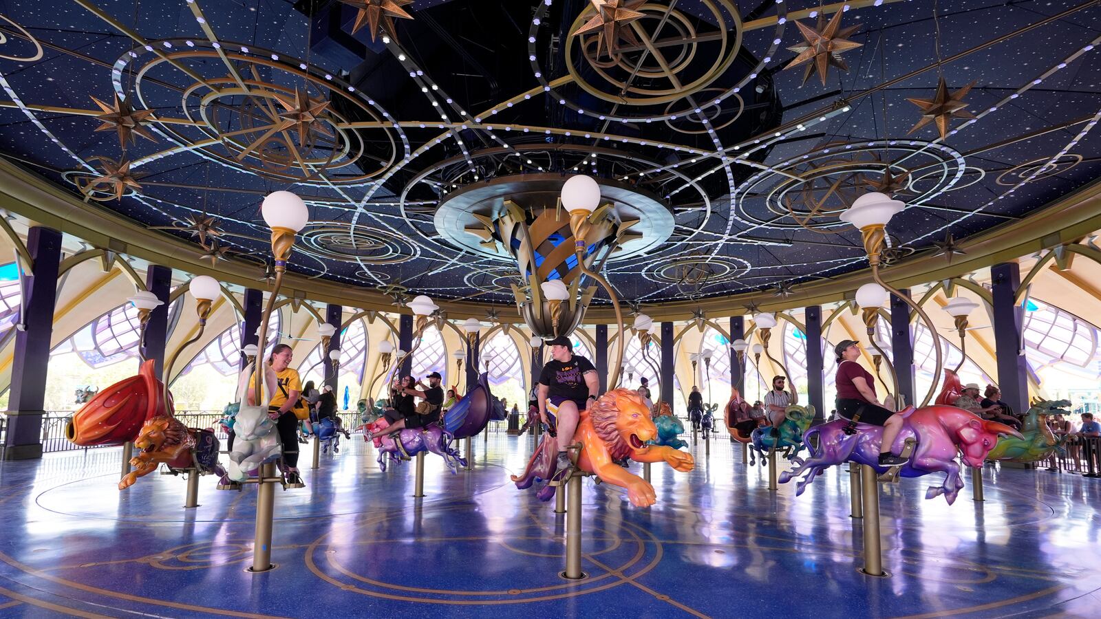 Guests ride the Constellation Carousel in Celestial Park in Epic Universe at Universal Resort Orlando Thursday, April 10, 2025, in Orlando, Fla. (AP Photo/John Raoux)