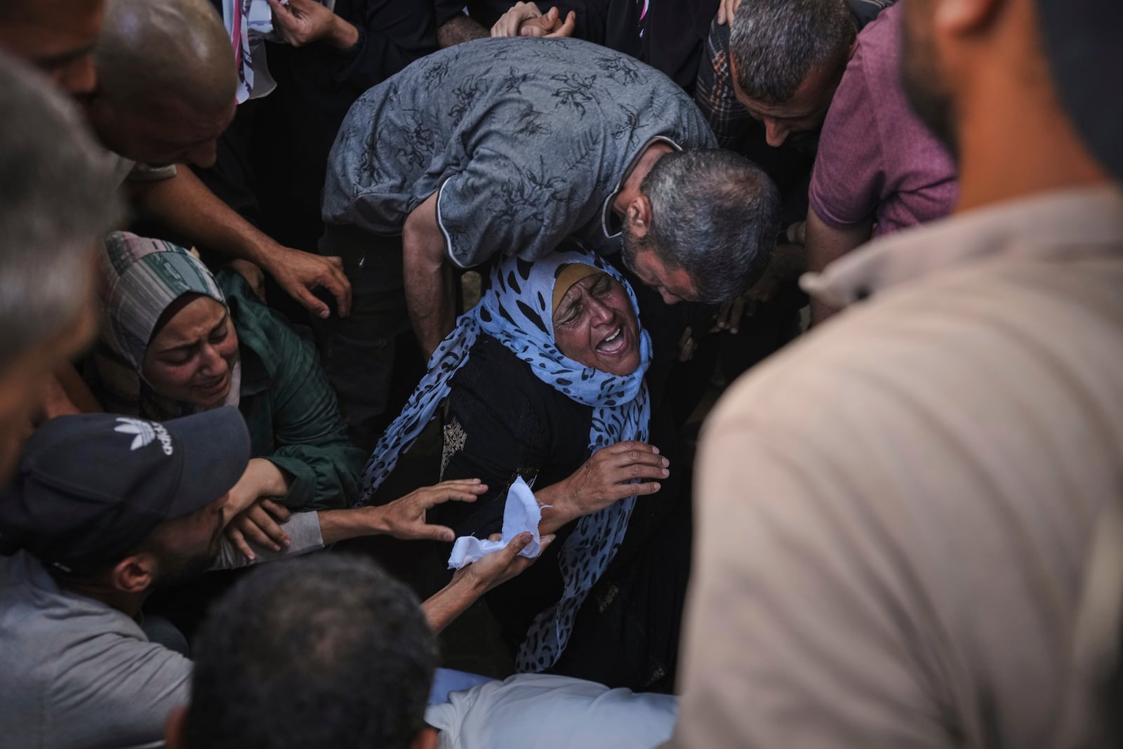 The mother of Anas Al-Basyouni mourns his loss shortly after he was killed while on his way to an aid distribution center, during his funeral at Shifa Hospital in Gaza City on Thursday, July 3, 2025. (AP Photo/Jehad Alshrafi)