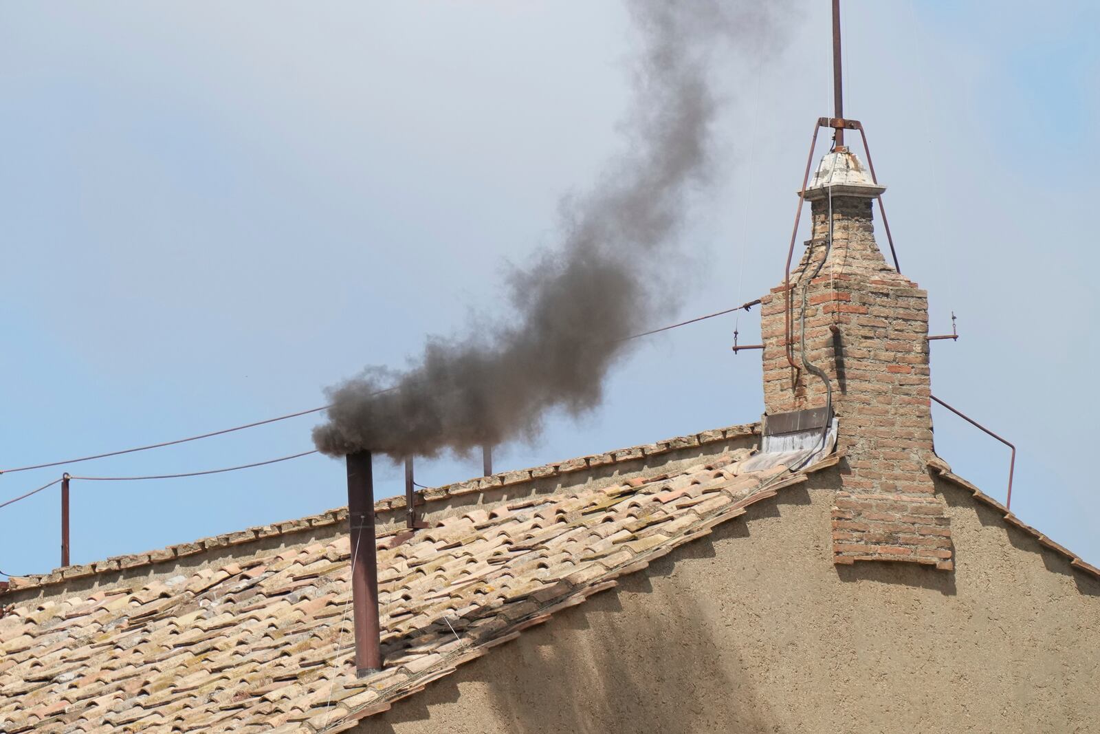 Black smoke billows from the chimney of the Sistine Chapel during the conclave to elect a successor of late Pope Francis, at the Vatican, Thursday, May 8, 2025. (AP Photo/Antonio Calanni)