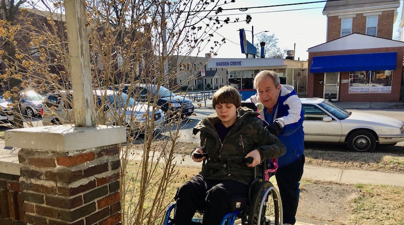 Veteran Hamilton Schools bus driver Bob Thacker pushes special needs student Katelynn Uhl up the access ramp Thacker built for her after helping her off his bus at the end of the school day. After watching Uhl and her mother fall and suffer injuries last month while struggling to get Katelynn’s wheel chair down the stairs, Thacker says he had to act. (Photo By Michael D. Clark/Journal-News)
