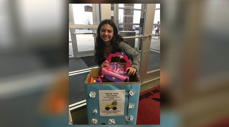 Fairfield High School junior Jill Rimer makes her donation to the Butler County school system’s annual toy drive for needy children in foster families. The Ton of Toys program, which is done through the Butler County Children Services, has relied for more than a decade on the enthusiastic volunteers like Rimer from the school. (Provided Photo/Journal-News)