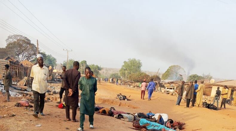CORRECTS DAY TO WEDNESDAY, NOT TUESDAY - EDS NOTE: GRAPHIC CONTENT - This photo provided by Kaiama TV shows people gathered around victims killed by armed extremists in the Woro community of western Nigeria, Wednesday, Feb. 4, 2026. (Kaiama TV via AP)