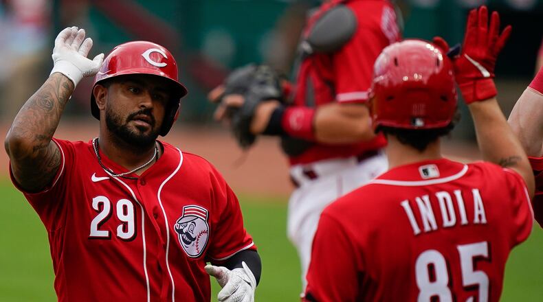 Cincinnati Reds' Christian Colon, left, celebrates with teammates after hitting a home run during team baseball practice at Great American Ballpark in Cincinnati, Friday, July 10, 2020. (AP Photo/Bryan Woolston)