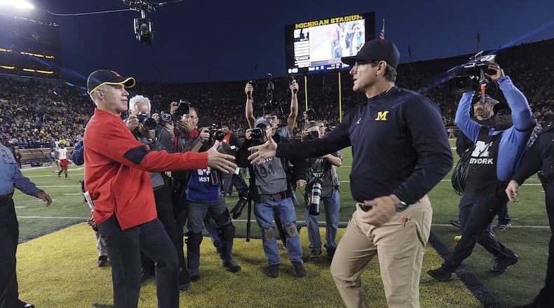 Maryland head coach DJ Durkin, front left, meets Michigan head coach Jim Harbaugh, front right, for a hand shake after an NCAA college football game in Ann Arbor, Mich., Saturday, Nov. 5, 2016. Michigan won 59-3. (AP Photo/Tony Ding)