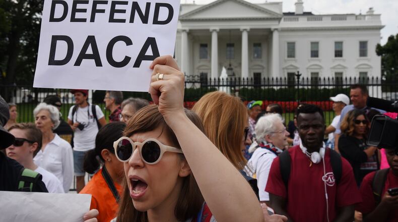 Protesters hold up signs during a rally supporting Deferred Action for Childhood Arrivals, or DACA, outside the White House on Tuesday, Sept. 5, 2017. Thousands are expected to gather for rallies on Tuesday, when President Donald Trump is slated to announce the program’s future. (Olivier Douliery/Abaca Press/TNS)