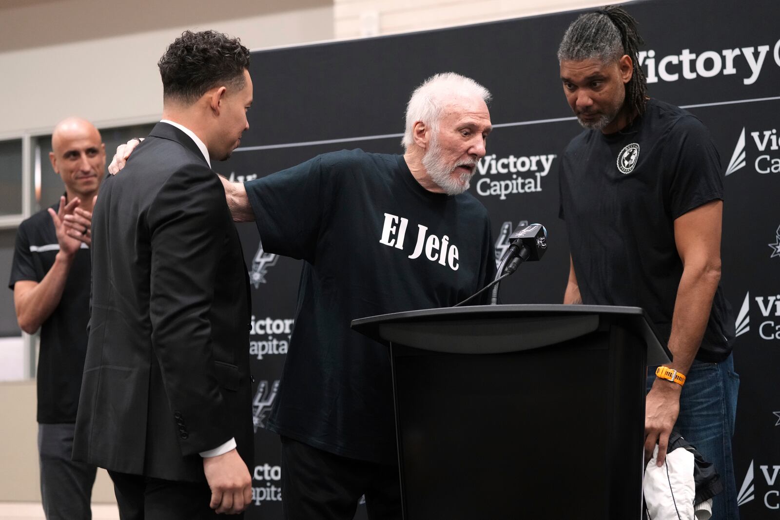 With the help of former players Manu Ginobili, back left, and Tim Duncan, right, former San Antonio Spurs head coach Gregg Popovich, center, introduces Mitch Johnson, front left, as the new head coach of the San Antonio Spurs NBA basketball team, in San Antonio, Monday, May 5, 2025. (AP Photo/Eric Gay)