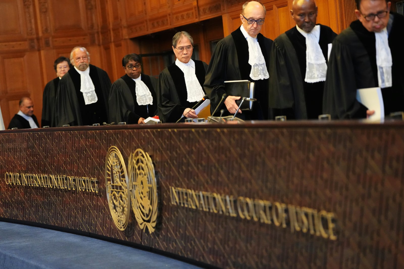 Presiding judge Yuji Iwasawa, fourth from right, enters the International Court of Justice ahead of an advisory opinion on what legal obligations nations have to address climate change and what consequences they may face if they don't, Wednesday, July 23, 2025, in The Hague, Netherlands. (AP Photo/Peter Dejong)