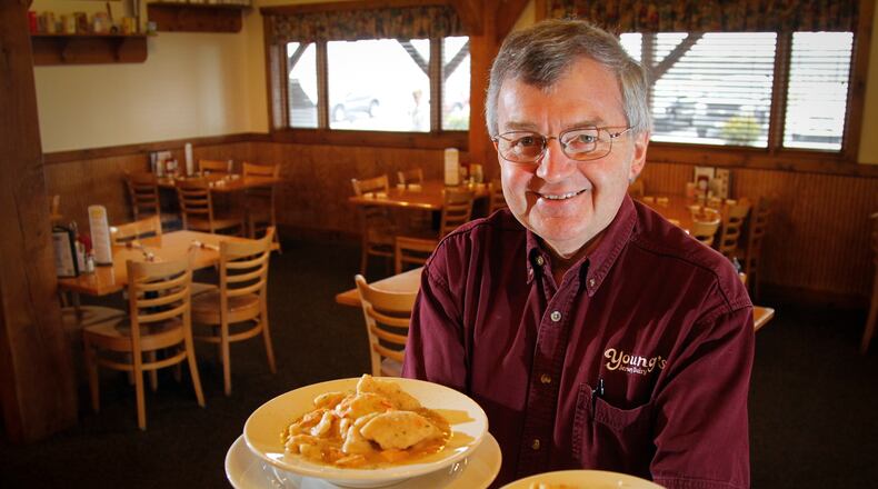 In this 2013 photo, Dan Young, owner of Young's Jersey Dairy and the Golden Jersey Inn in Clark County north of Yellow Springs, serves two sizes of chicken and dumplings. Young said Sunday that the Golden Jersey Dairy, which has been shut down since March 2020 due to the coronavirus pandemic, will not reopen as a full-service restaurant, but will instead be transformed into events space to be called Young's Events Center. File photo by LISA POWELL / STAFF