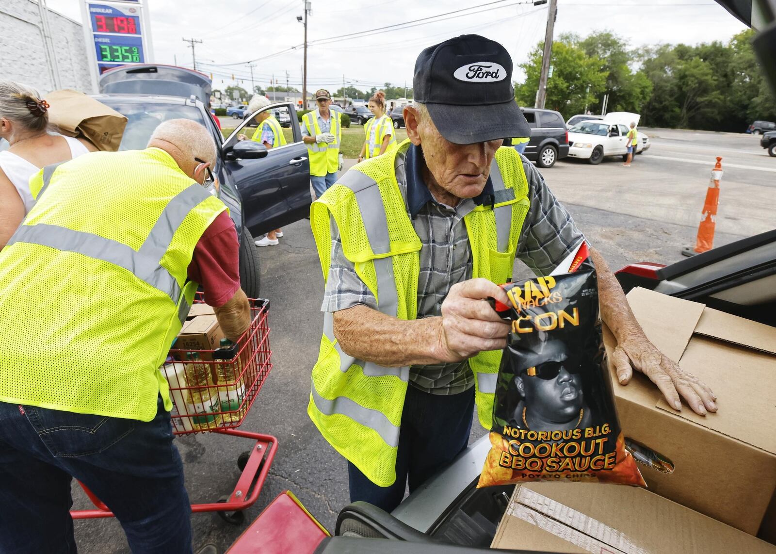 Charlie Withrow loads a car during a food distribution Wednesday, Aug. 3, 2021, at Village Food Pantry in New Miami. The pantry provides food for nearly 200 families a week. NICK GRAHAM/STAFF