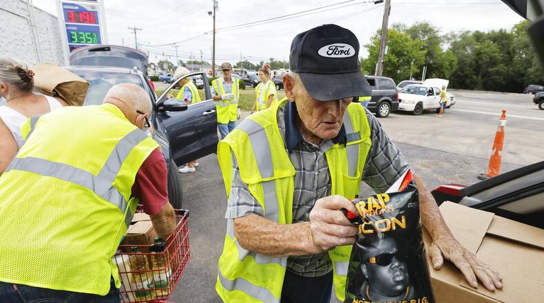 Charlie Withrow loads a car during a food distribution Wednesday, Aug. 3, 2021, at Village Food Pantry in New Miami. The pantry provides food for nearly 200 families a week. NICK GRAHAM/STAFF