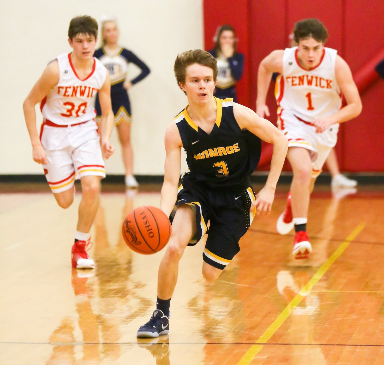 Monroe guard Devon Hubbard (3) brings the ball up the floor as Fenwick’s John Engelmeier (30) and Zachary Lorei (1) give chase Tuesday night at Fenwick. GREG LYNCH/STAFF