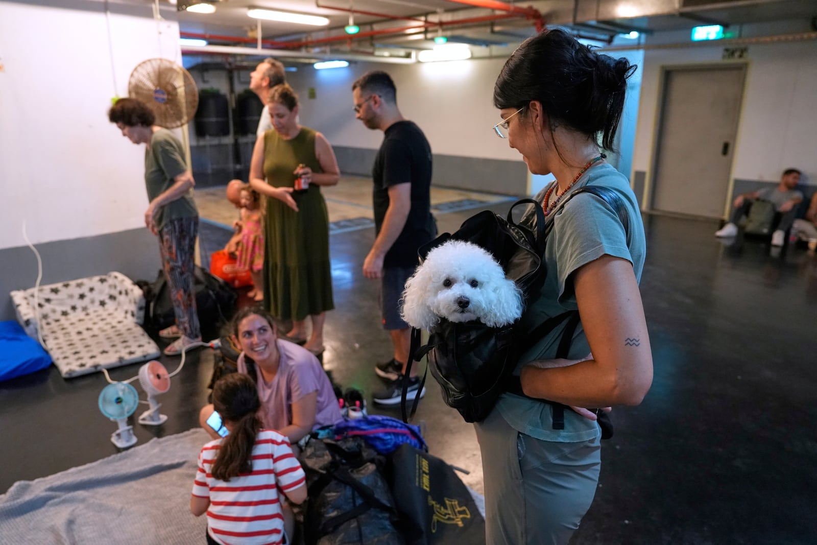 Israelis get ready to take shelter in a parking garage in prevention of a missile attack from Iran, in Tel Aviv, Israel, Monday, June 16, 2025. (AP Photo/Baz Ratner)