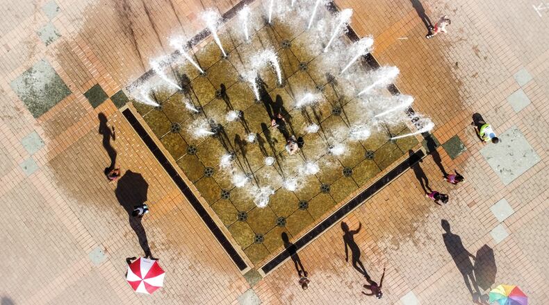 RiverScape Metropark fountain on Monument Ave. In Dayton was busy Tuesday afternoon. The temperature was well into the 90s and the cool water tempted adults as well as children. Jim Noelker/Staff