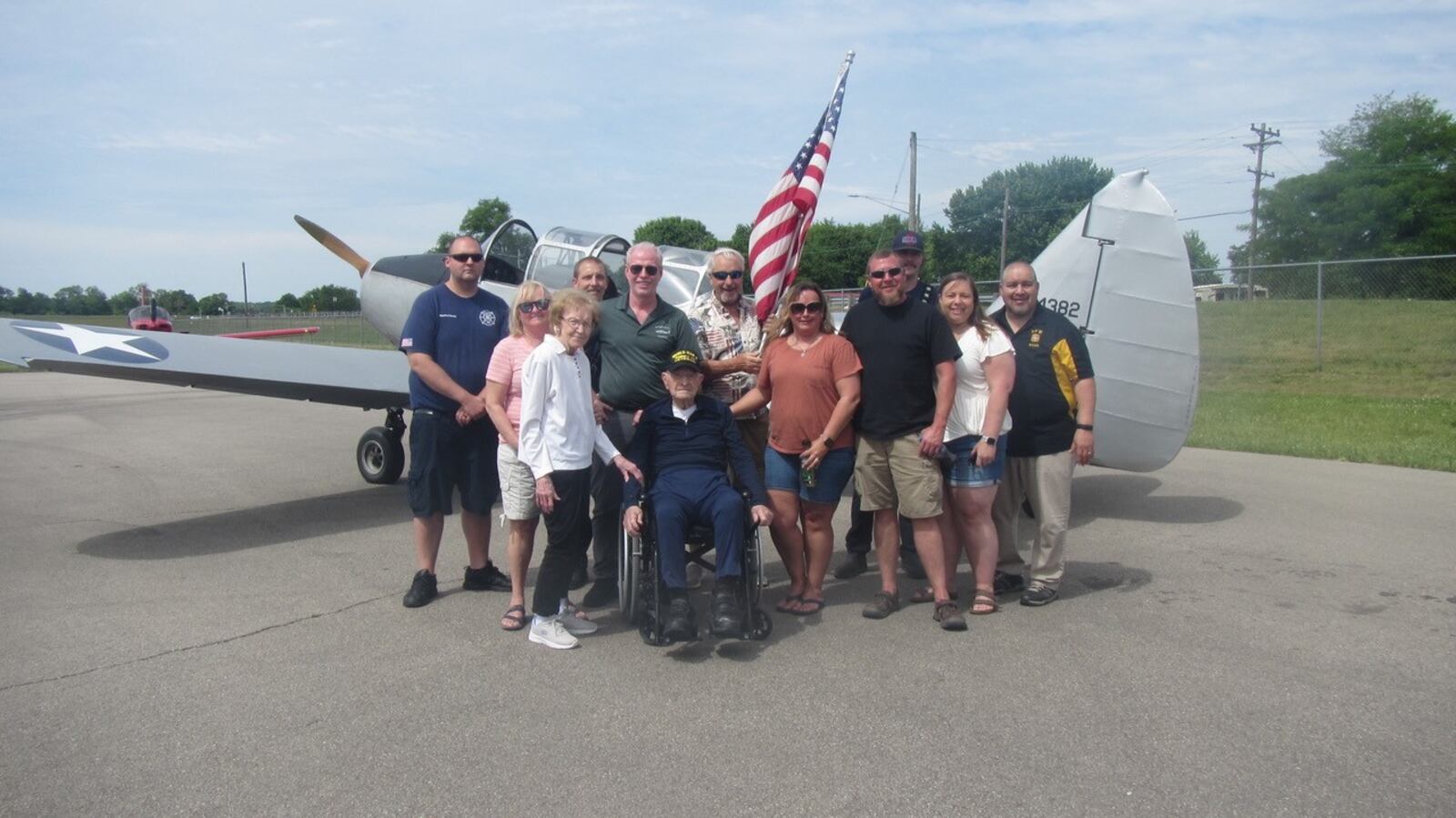 World War II veteran Richard "Dick" Gard, 100, who piloted a 1943 PT19-A Cornell two-seat warplane Saturday at Middletown Regional Airport, is surrounded by his family, friends and those who made the flight possible. He flew with pilot Tim Epperhart, president of the Butler County Warbirds that are based at the airport. SUBMITTED PHOTO