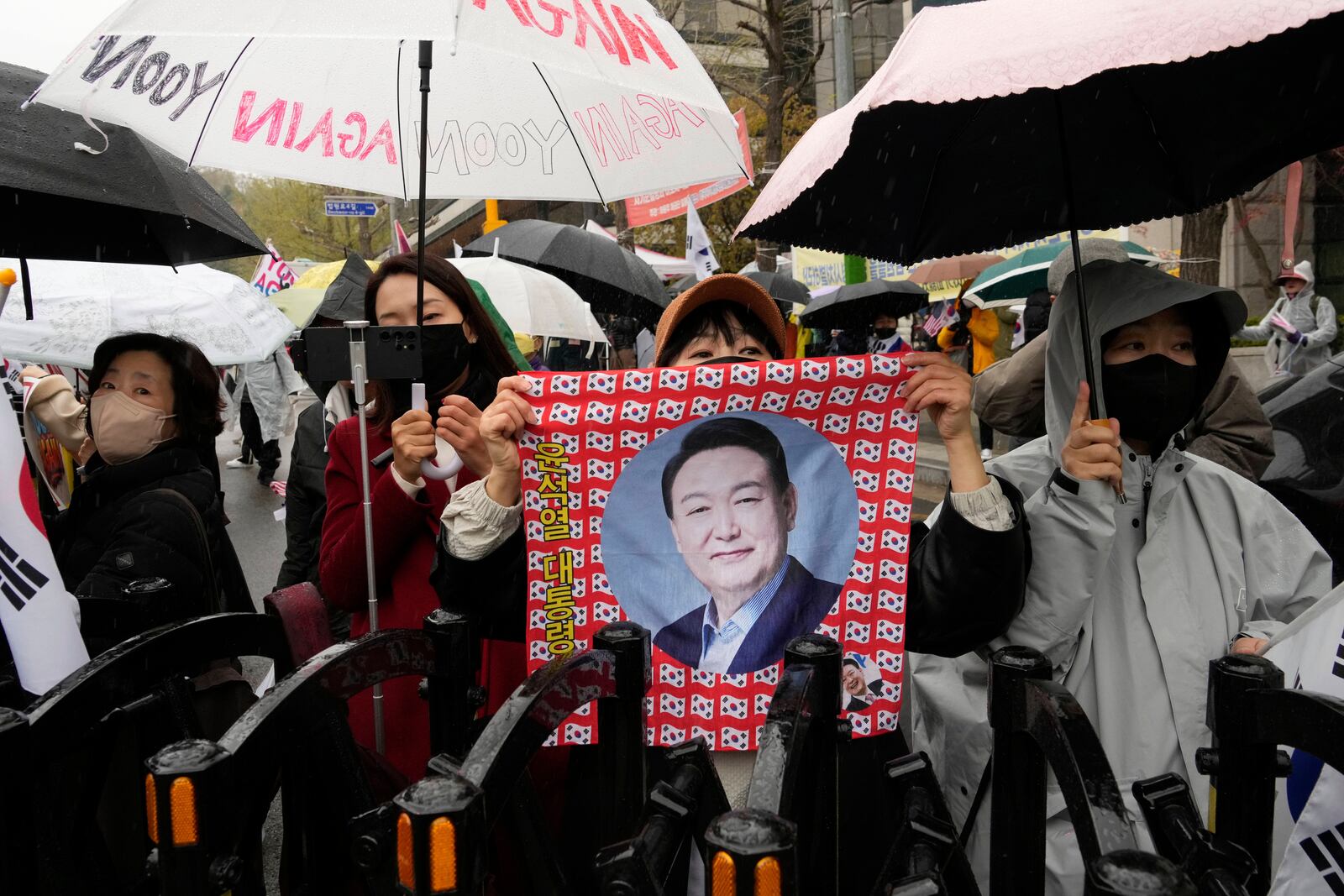 Supports of South Korea's ousted President Yoon Suk Yeol stand to call for the cancellation of his removal in front of the Seoul Central District Court in Seoul, South Korea, Monday, April 14, 2025. (AP Photo/Ahn Young-joon)
