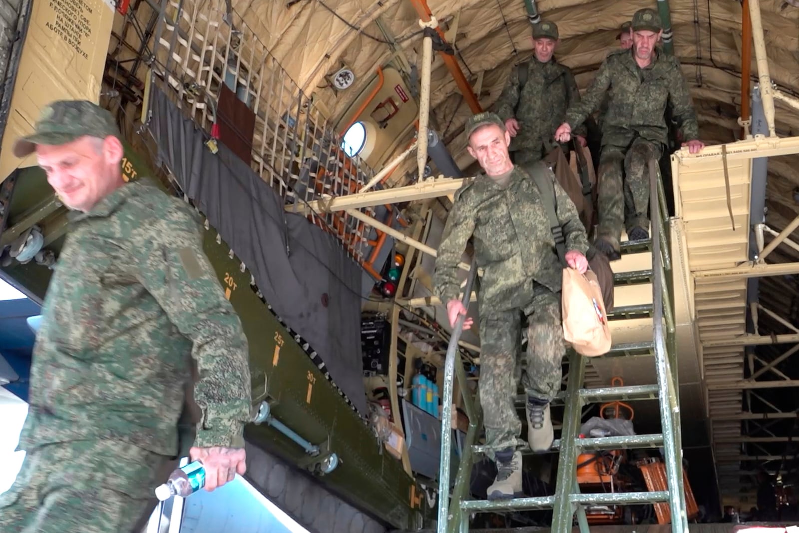 In this photo taken from video released by Russian Defense Ministry Press Service on Sunday, May 25, 2025, Russian servicemen leave a plane upon arrival to Chkalovsky airport, outside Moscow, Russia, after returning from captivity by a POWs exchange between Russia and Ukraine. (Russian Defense Ministry Press Service photo via AP)